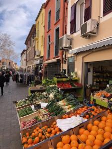 un mercado con naranjas y otras frutas y hortalizas en la calle en Appartement catalan coeur village, en Argelès-sur-Mer