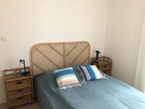 Una cama con sábanas azules y dos almohadas. en Appartement catalan coeur village, en Argelès-sur-Mer