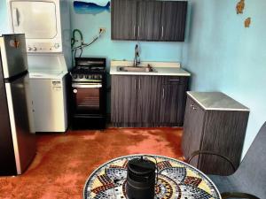 a small kitchen with a table in the middle of it at La Casa azul de Rincon in Rincon