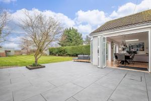 a patio with a couch and a table at Stunning 3 Bed 2 Bath Detached Village Home in Cheltenham