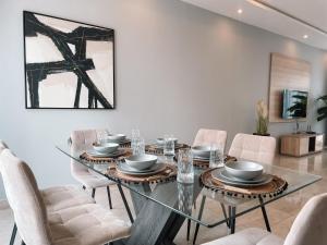 a dining room with a glass table and chairs at 3BR house in Tema 25 in Tema