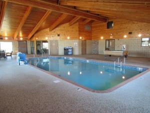 a large swimming pool in a building with a pool table at AmericInn by Wyndham Lincoln South in Lincoln