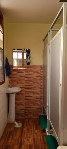 y baño con lavabo y ducha. en Hostel The Little House Backpakers en La Paz