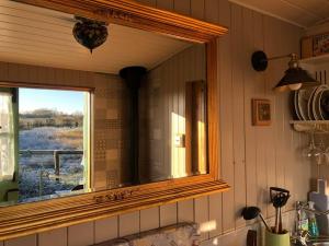 a mirror above a sink in a kitchen at Shepherd’s Hut with complete privacy in Bottesford