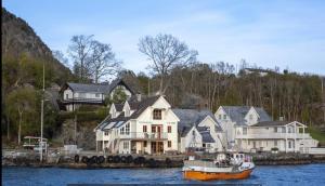 a boat in the water next to a group of houses at Salteriet in Vinnes