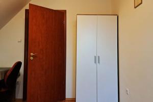 - un placard blanc à côté d'une porte en bois dans l'établissement Zöld Orom Apartman Lakás, à Göd