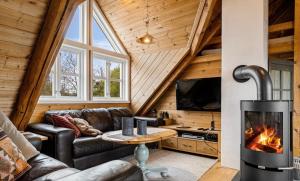a living room with a fireplace in a log cabin at Salteriet in Vinnes
