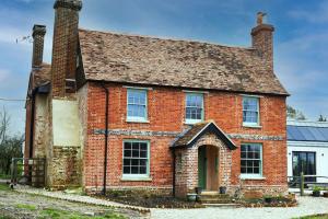 an old red brick house with two chimneys at Air Maison - Newlands Farm Grade II Listed Georgian Farmhouse in Waterlooville