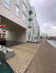 un grand bâtiment sur un trottoir à côté d'une rue dans l'établissement Apartment Viesturdārz, à Riga