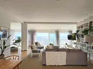 sala de estar con sofá, sillas y mesa en Beach House - Number 49, en Ciudad del Cabo