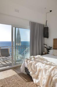 a bedroom with a bed and a view of the ocean at Beach House - Number 49 in Cape Town