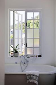 a bath tub in a bathroom with a window at Beach House - Number 49 in Cape Town