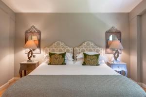 a bedroom with a large white bed with two lamps at Percy in Richmond
