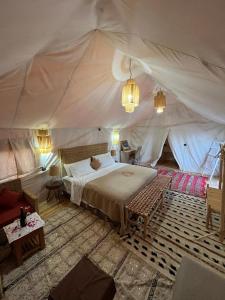 Mhamid Luxury Camp في Mhamid: غرفة نوم بسرير في خيمة