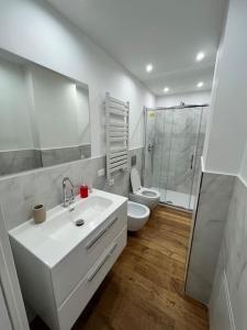 a white bathroom with a toilet and a sink at Lazio apartment nel centro di Palermo in Palermo