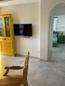 - un salon avec une télévision murale dans l'établissement Marsa - Sidi Bousaid Lovely Authentic Apartment, à La Marsa