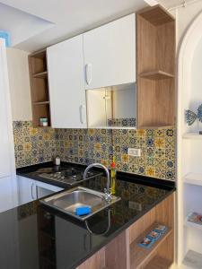 Il comprend une cuisine équipée d'un évier et d'une cuisinière. dans l'établissement Marsa - Sidi Bousaid Lovely Authentic Apartment, à La Marsa