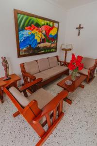 a living room with a couch and tables and a painting at Casa Hotel Miriam in Montería