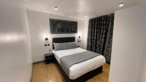 een slaapkamer met een groot bed en een raam bij Pasha Hotel - 3* Boutique Hotel in Londen