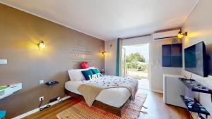 a bedroom with a large bed and a large window at 150 de Grey Studio pour 2 avec SPA, Vue sur mer in La Trinité