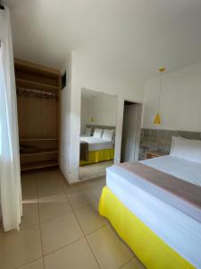 una camera d'albergo con due letti e uno specchio di Pousada Aliany Lôbo a Pirenópolis