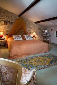 ein Schlafzimmer mit einem Bett in einer Steinmauer in der Unterkunft Mas de Bombequiols in Saint-André-de-Buèges