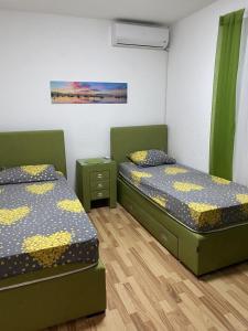 two twin beds in a room with green beds sidx sidx sidx at Milica Apartments in Sutomore