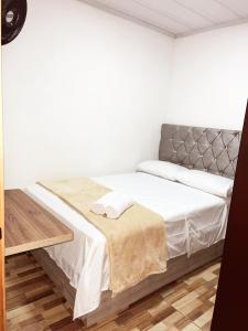 a white bedroom with a bed with white sheets at Alojamiento Villasofia in Armenia