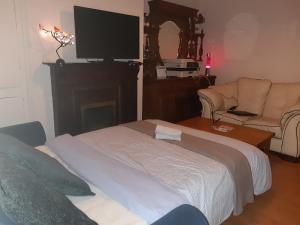 sala de estar con cama y TV de pantalla plana en Phoenix Nights Guest House en Barrow in Furness
