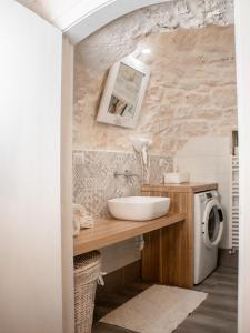 a bathroom with a sink and a washing machine at Masseria trulli pietra antica in Noci