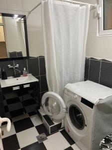 a bathroom with a washing machine and a sink at Milica Apartments in Sutomore