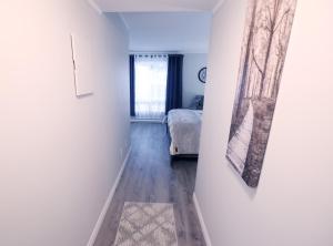 a hallway with a bed and a painting on a wall at Newly renovated suite in Elliot Lake