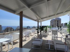 eine Terrasse mit Tischen und Stühlen auf dem Dach in der Unterkunft Flamingo Beach Resort - Adults Recommended in Benidorm