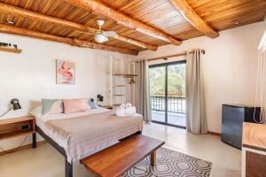 een slaapkamer met een bed, een bureau en een televisie bij Believe Surf & Yoga Lodge Santa Teresa in Santa Teresa Beach