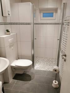 a white bathroom with a shower and a toilet at Schön gelegene Ferien-/Pendlerwohnung nahe Rothaarsteig mit guter Anbindung in Haiger