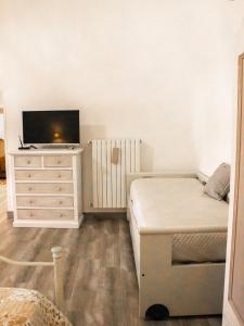 ein Schlafzimmer mit einem Bett und einem TV auf einer Kommode in der Unterkunft Masseria trulli pietra antica in Noci