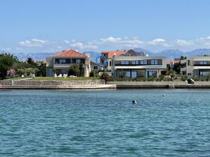 a house on the shore of a body of water at Apartman Loren in Privlaka