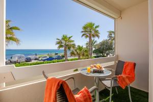 balcón con mesa, sillas y vistas al océano en Hôtel La Plage, en Sainte-Maxime