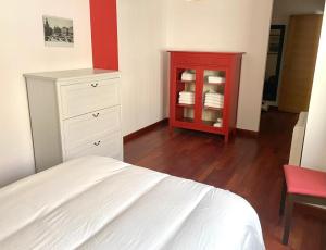 a bedroom with a red cabinet and a bed at Puebla :) in A Pobra do Caramiñal +9 photos