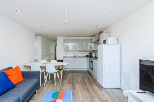 a living room with a blue couch and a kitchen at May Disc - Long Stay - Contractors in Bristol