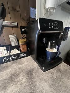 a coffee maker with a cup of coffee in it at KB Basement Apartment in Sørvågen