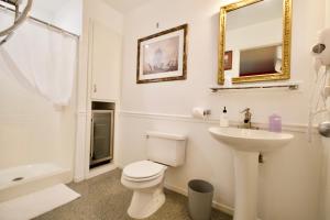 a white bathroom with a toilet and a sink at Yosemite Bug Rustic Mountain Resort in Midpines