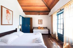a bedroom with two beds and a large window at Casa do canto in Búzios