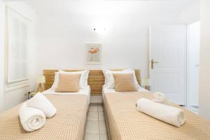 a room with three beds with towels on them at Sea and Sun beach house at Platis Gialos in Platis Gialos