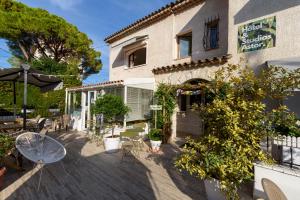 un patio de un edificio con sillas y plantas en Hôtel & Studios Astor, en Juan-les-Pins