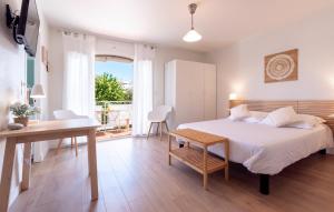 een slaapkamer met een bed, een tafel en een bureau bij Hôtel & Studios Astor in Juan-les-Pins