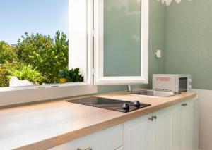 a kitchen with a sink and a window at Hôtel & Studios Astor in Juan-les-Pins