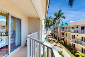 a balcony with a view of a hotel with palm trees at The Palm Bay Club Unit 311 in Siesta Key