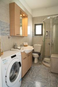 een badkamer met een wasmachine en een wastafel bij V&V Acropolis view apartment in Athene
