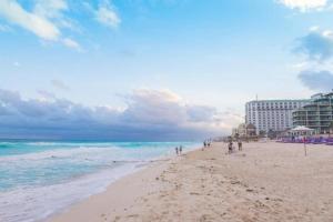 a group of people walking on the beach at Villa del Mar in Cancún